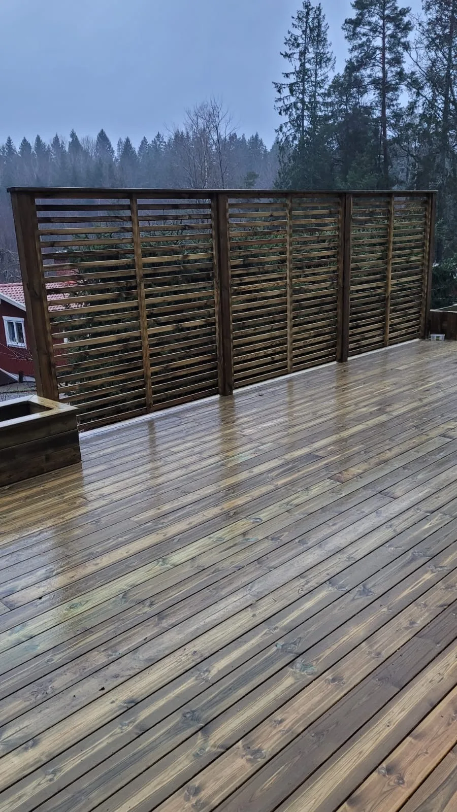 Trädäck med en snygg avskärmning i trä, perfekt för utomhusområden